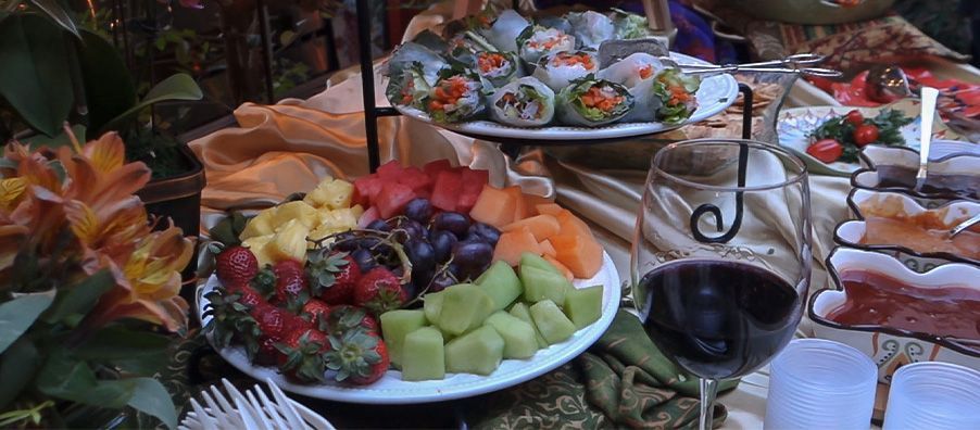 Fruit platter and spring roll platter with sauces and a wine glass