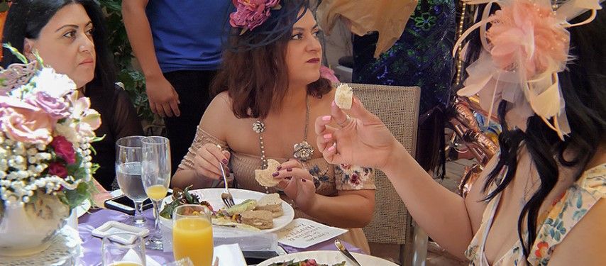 Ladies at a dining table eating tea sandwiches 