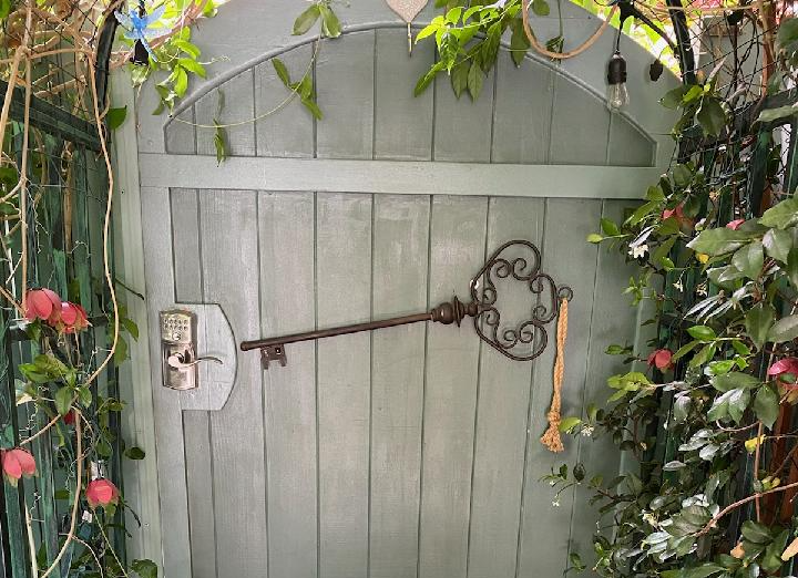 A wooden gate with a large key on it.