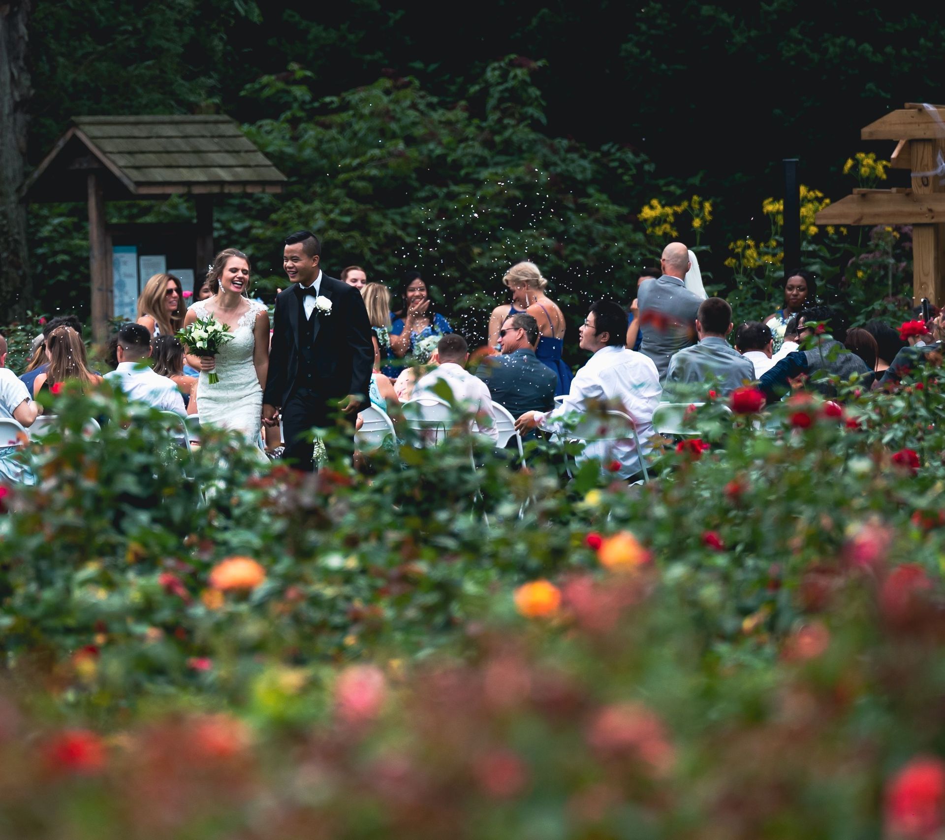 Wedding couple in a garden with guests