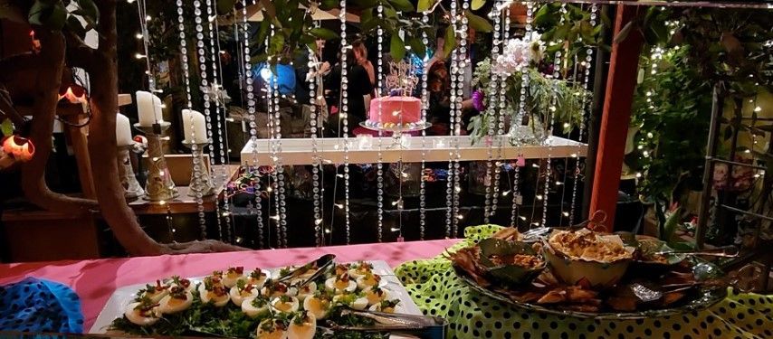 Looking from cocktail appetizer table at cake in bexx secret garden