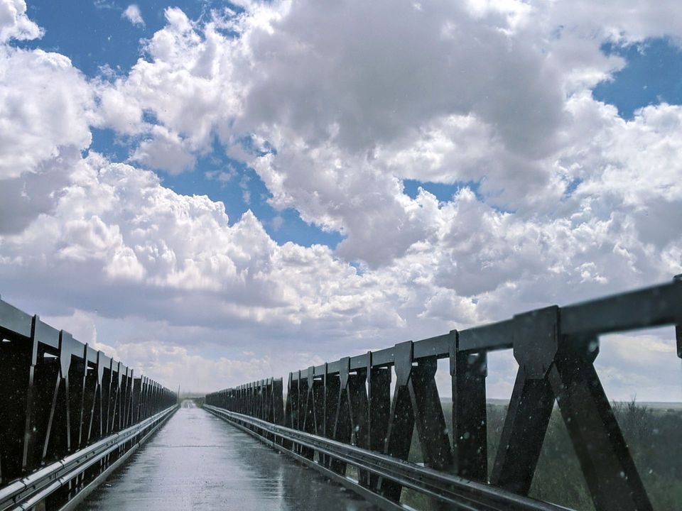 A bridge with a cloudy sky in the background