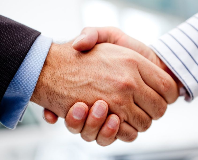 Two men are shaking hands in a close up of their hands
