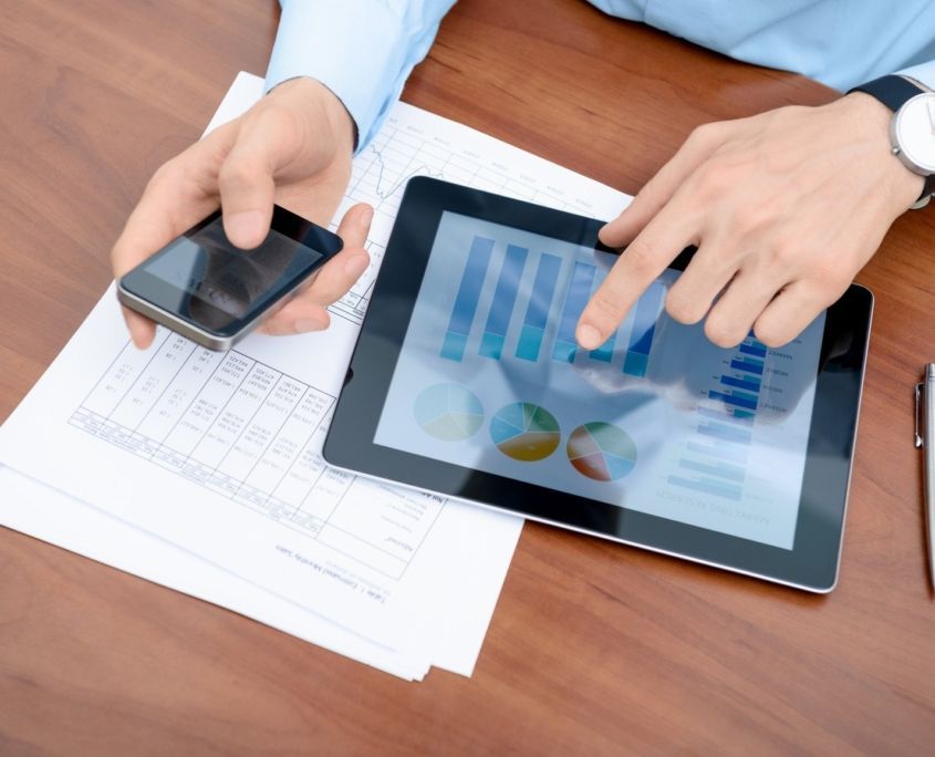 A man is using a tablet and a cell phone