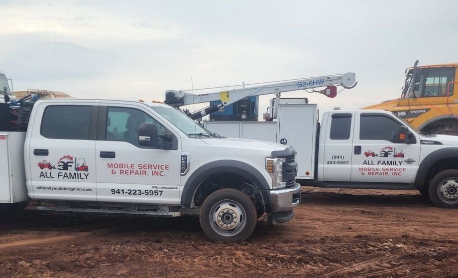 Two white work trucks with company logo parked outdoors.