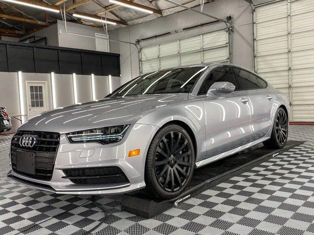 A silver audi a7 is parked in a garage.