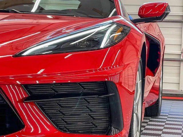 A red sports car is parked in a garage.