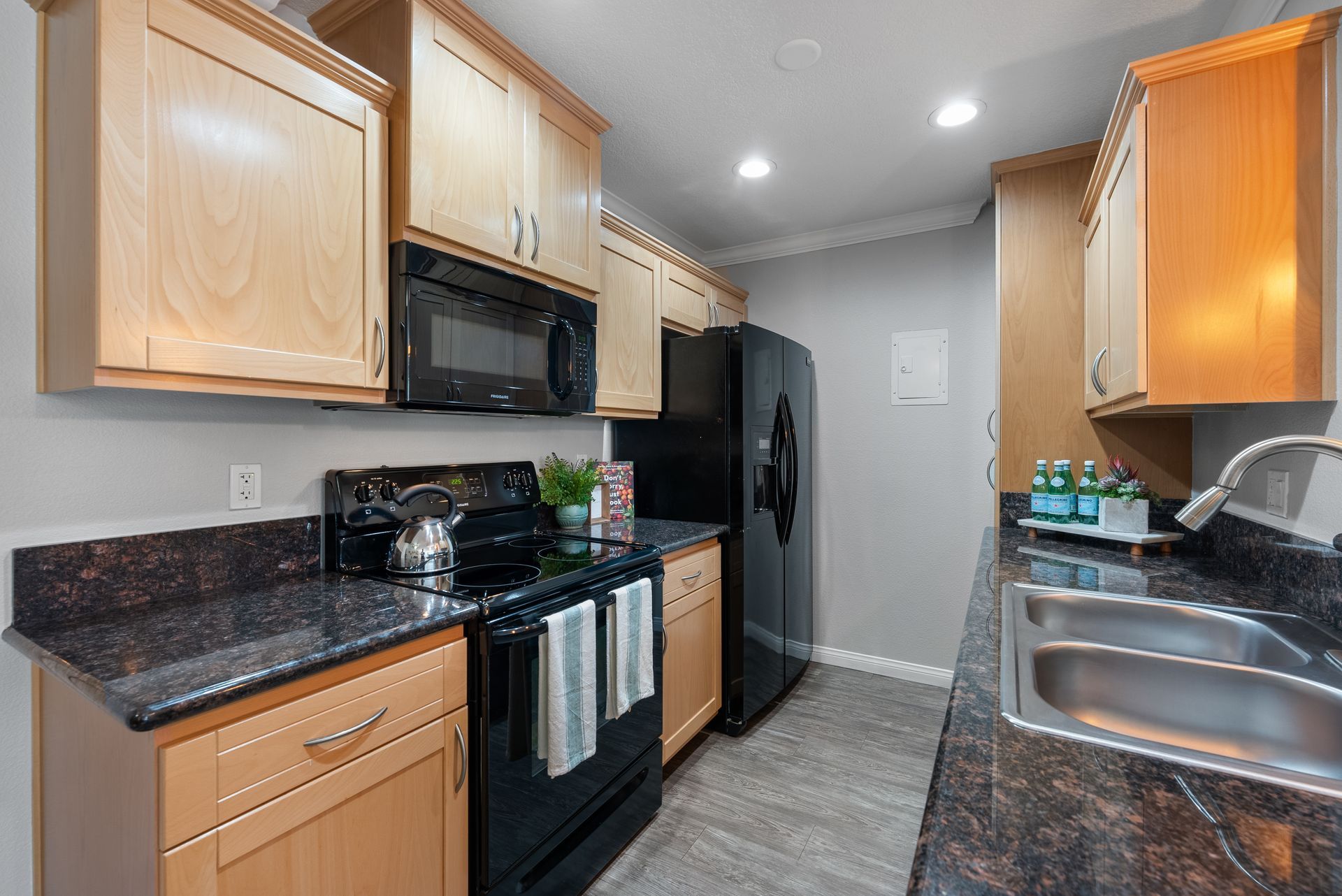 Kitchen with stove, sink, microwave, and fridge