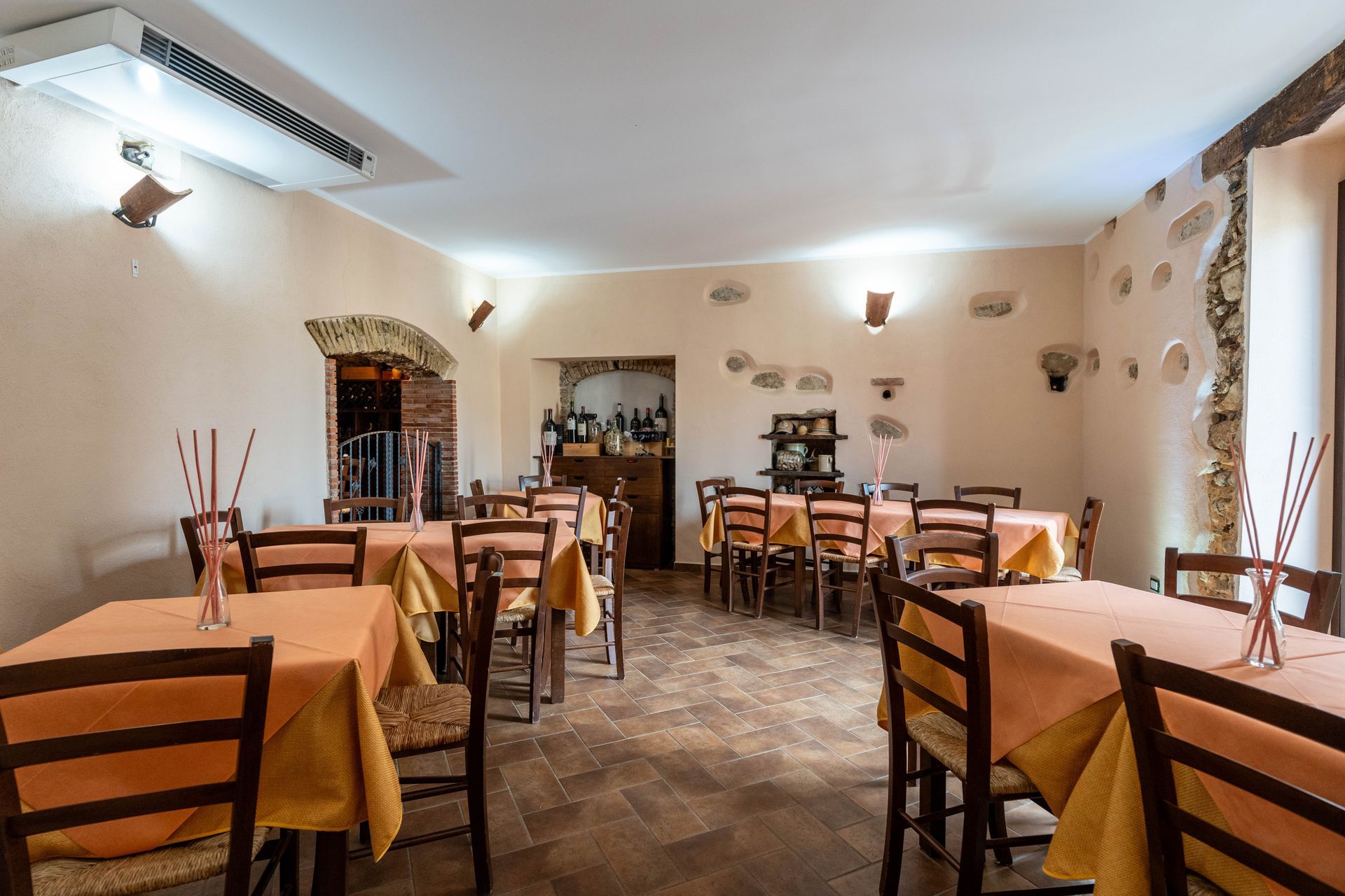 Un ristorante con tavoli e sedie con tovaglie arancioni