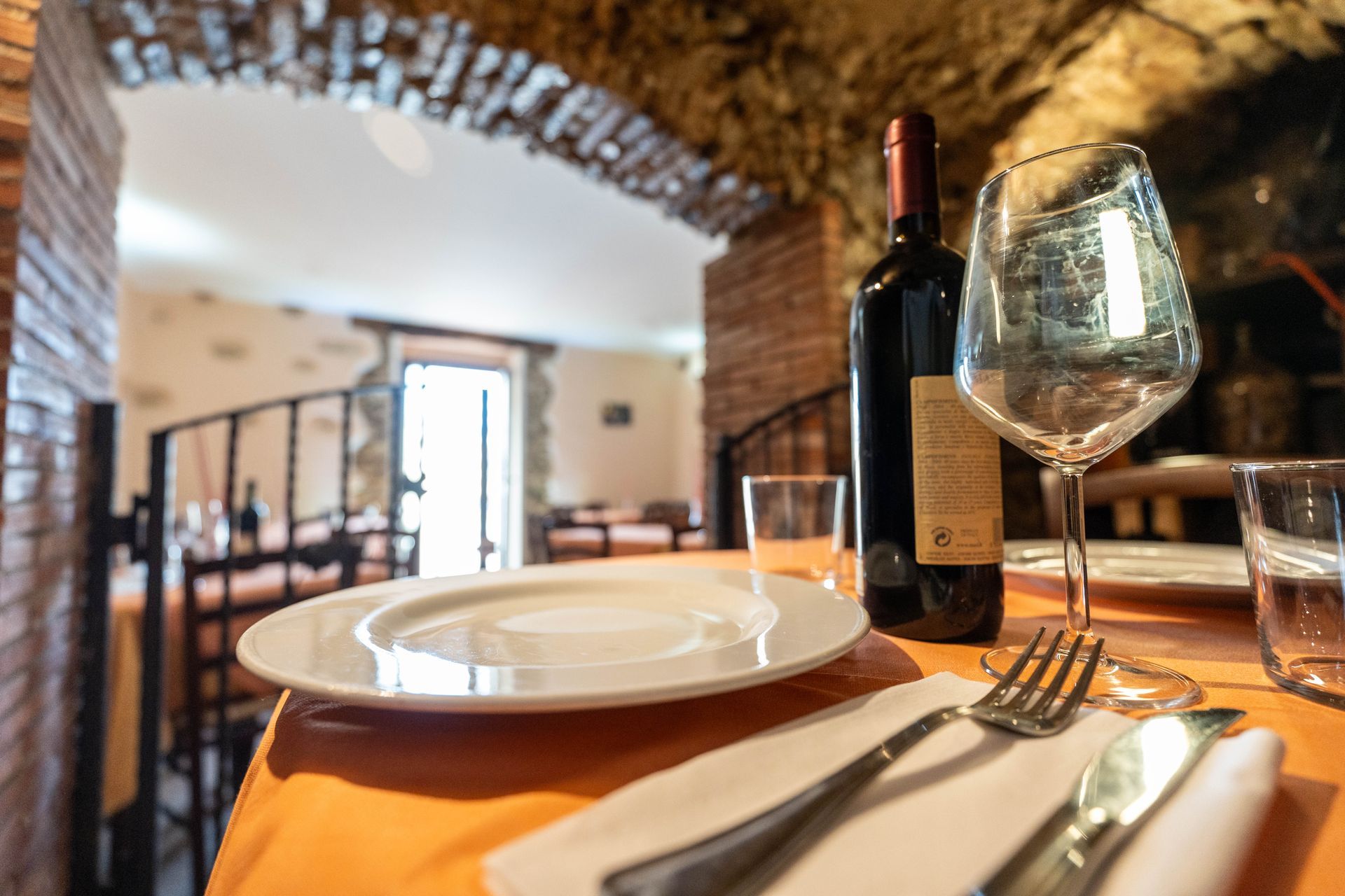 Una bottiglia di vino è appoggiata su un tavolo accanto a un bicchiere