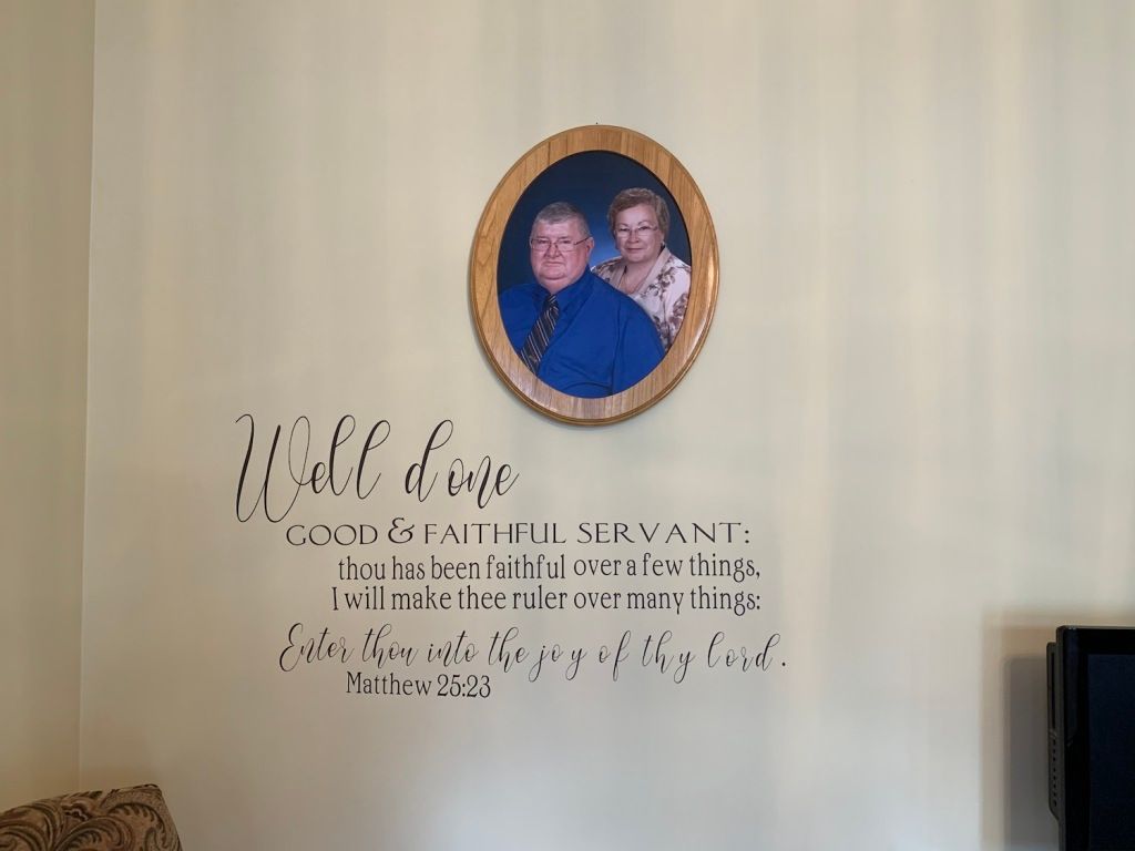 Wall décor with an oval portrait above cursive quote text on a beige wall