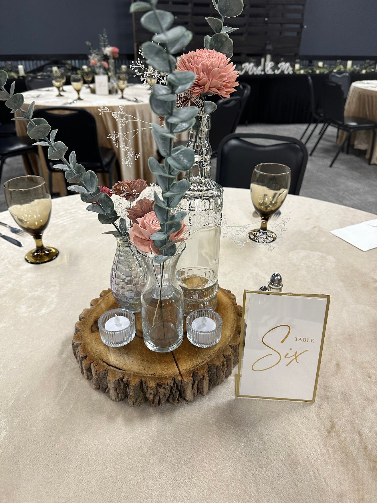 Table centerpiece with flowers and candles on a round banquet table in a reception hall