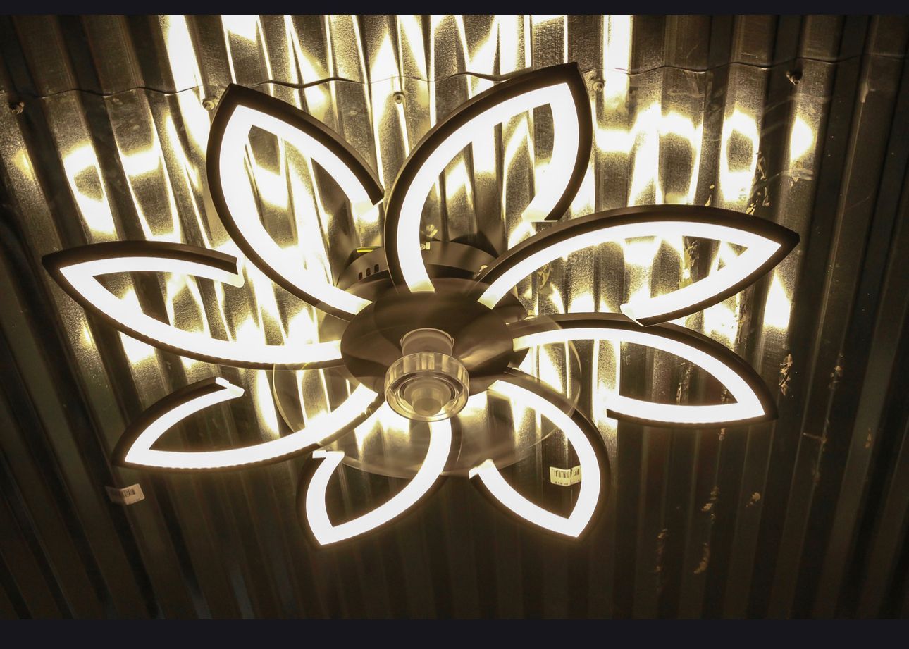 Floral-shaped ceiling light with glowing white LED outlines against a dark reflective ceiling