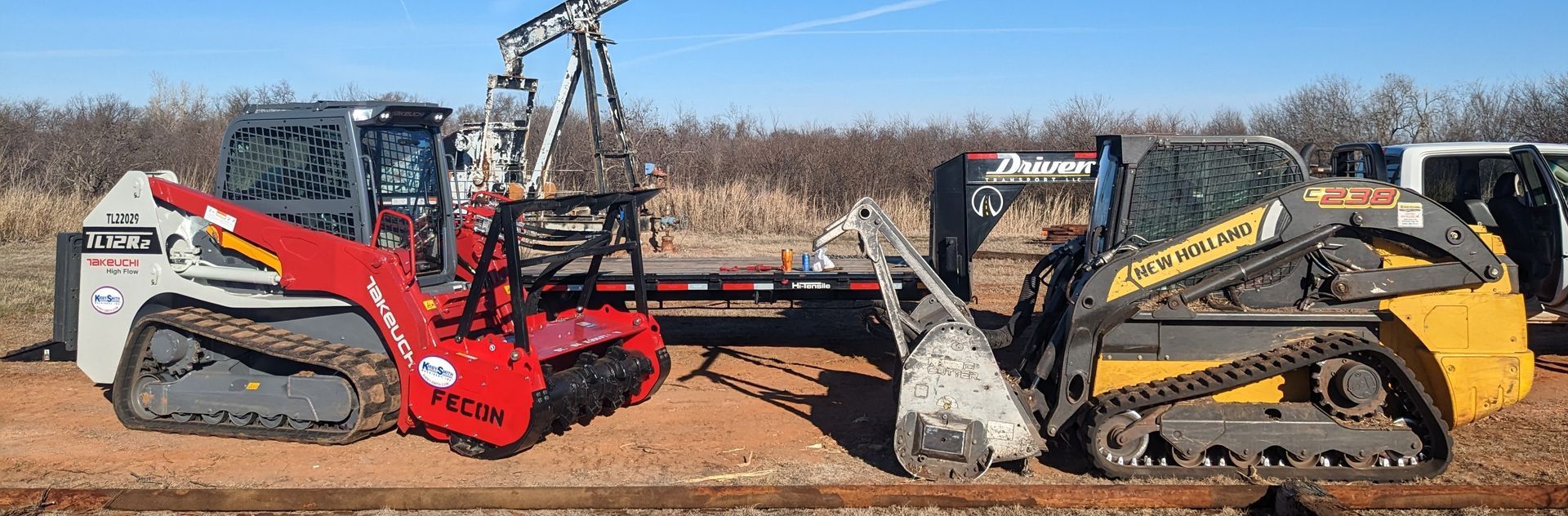 Red and yellow compact excavators with buckets facing each other on a dirt lot