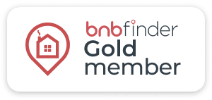 A logo for bnbfinder gold member with a house in the center.