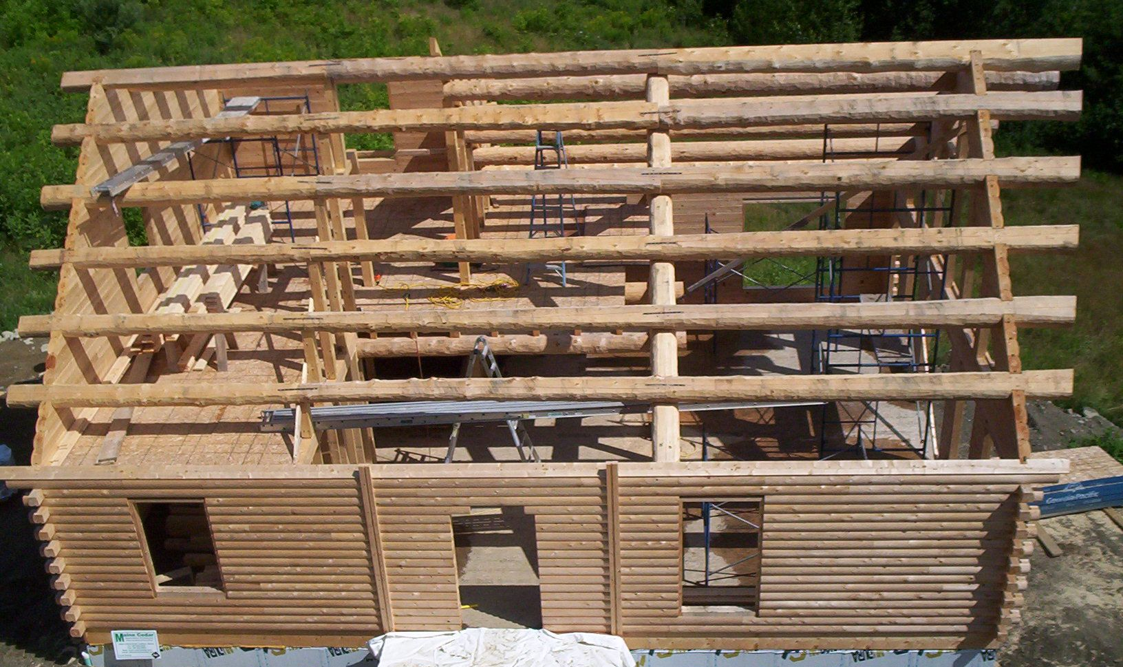 Wooden house frame under construction with exposed roof beams and unfinished walls