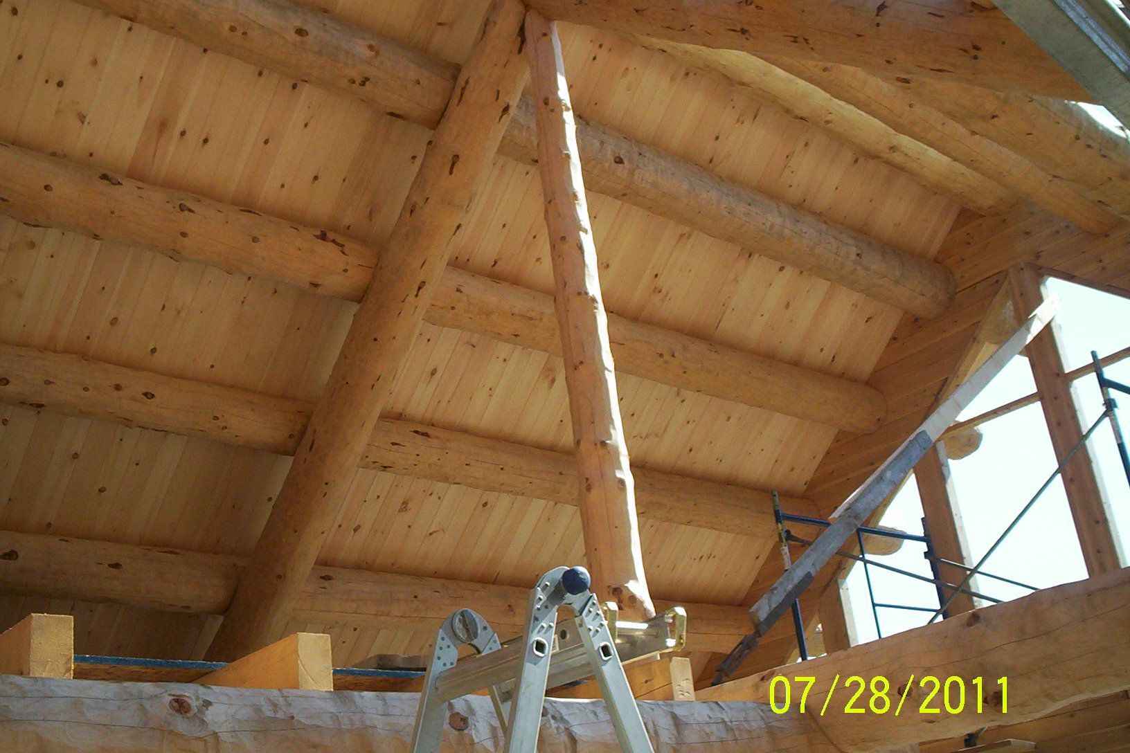 Wooden attic interior with exposed rafters and a ladder below, dated 07/28/2011.
