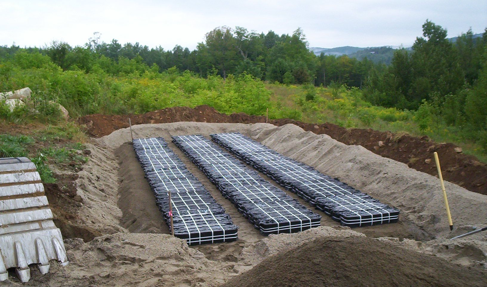 Construction site with trenches and stacked concrete blocks in a sandy area