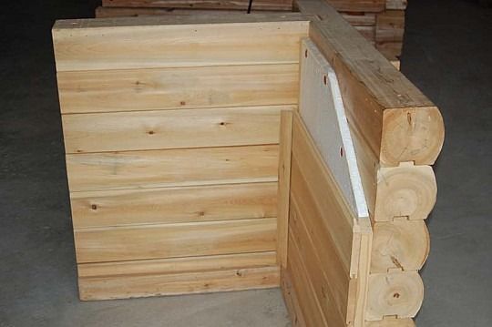 Wooden livestock crate or pen with slatted panels and log-style corner posts