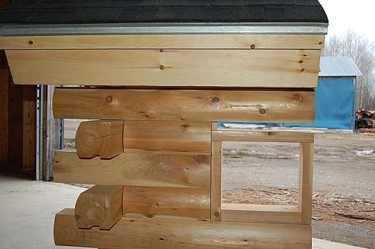 Wooden log cabin wall corner with interlocking logs and a small window opening