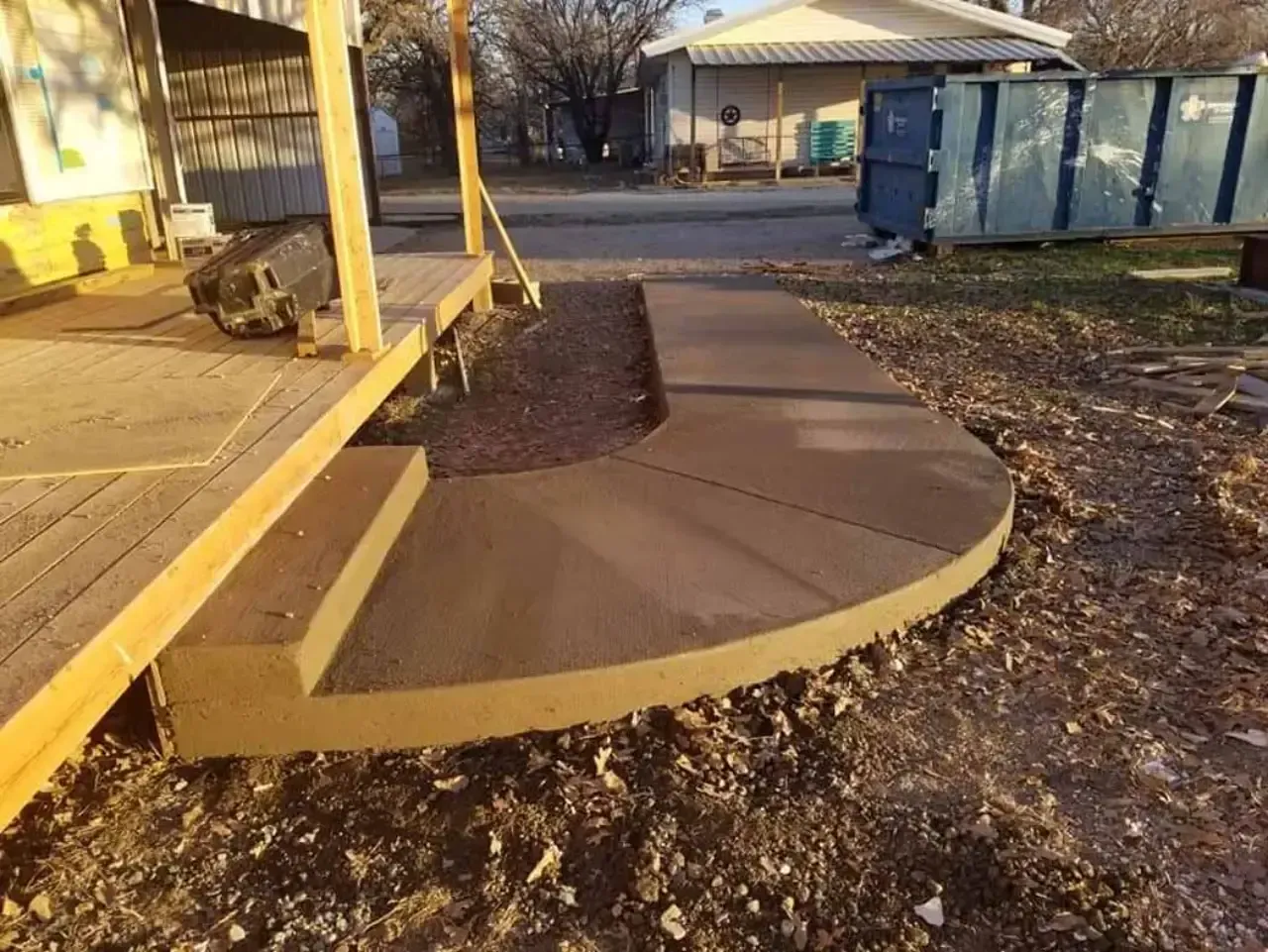 A concrete walkway is being built in front of a house.