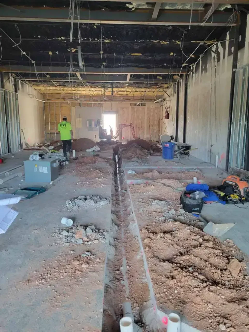 A large building under construction with a lot of dirt on the floor.
