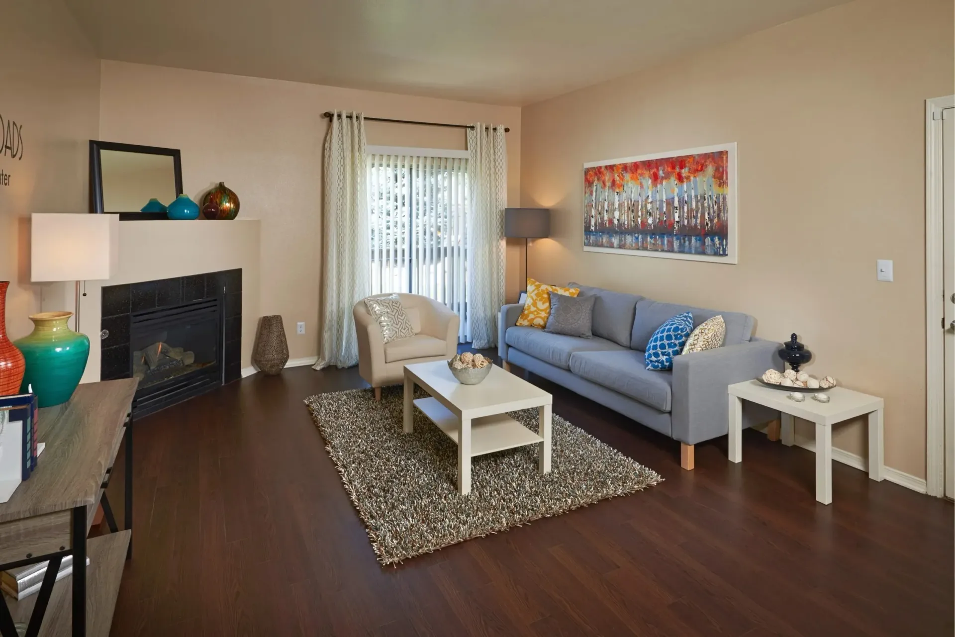 Cozy living room with a fireplace, sofa, armchair, and coffee table.