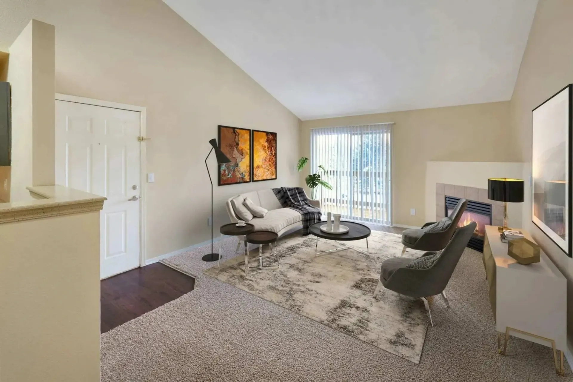 Living room with vaulted ceilings, fireplace, and large windows.