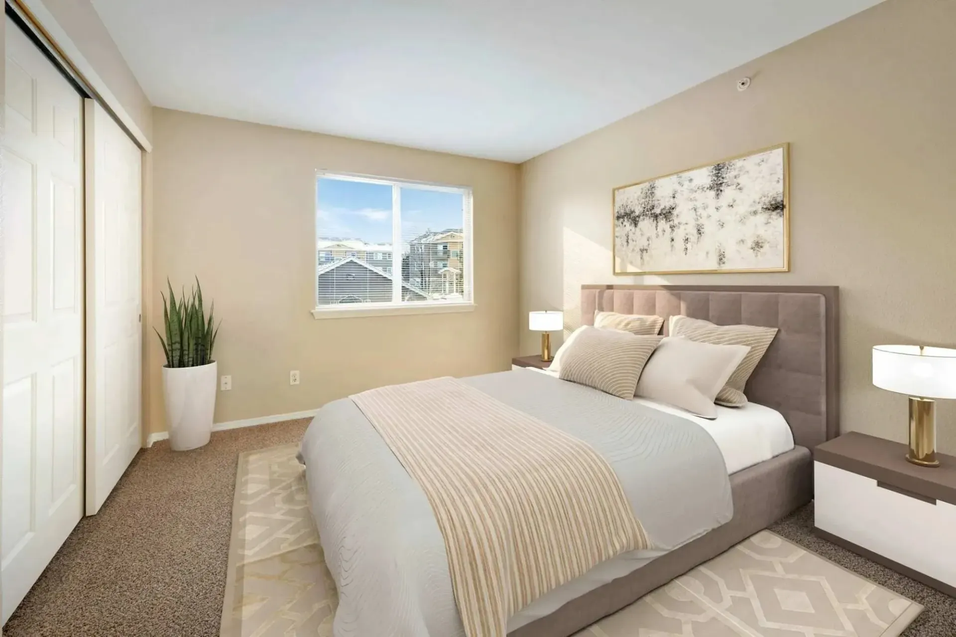 Bedroom with a queen-sized bed, sliding closet doors, and a window overlooking apartment buildings.