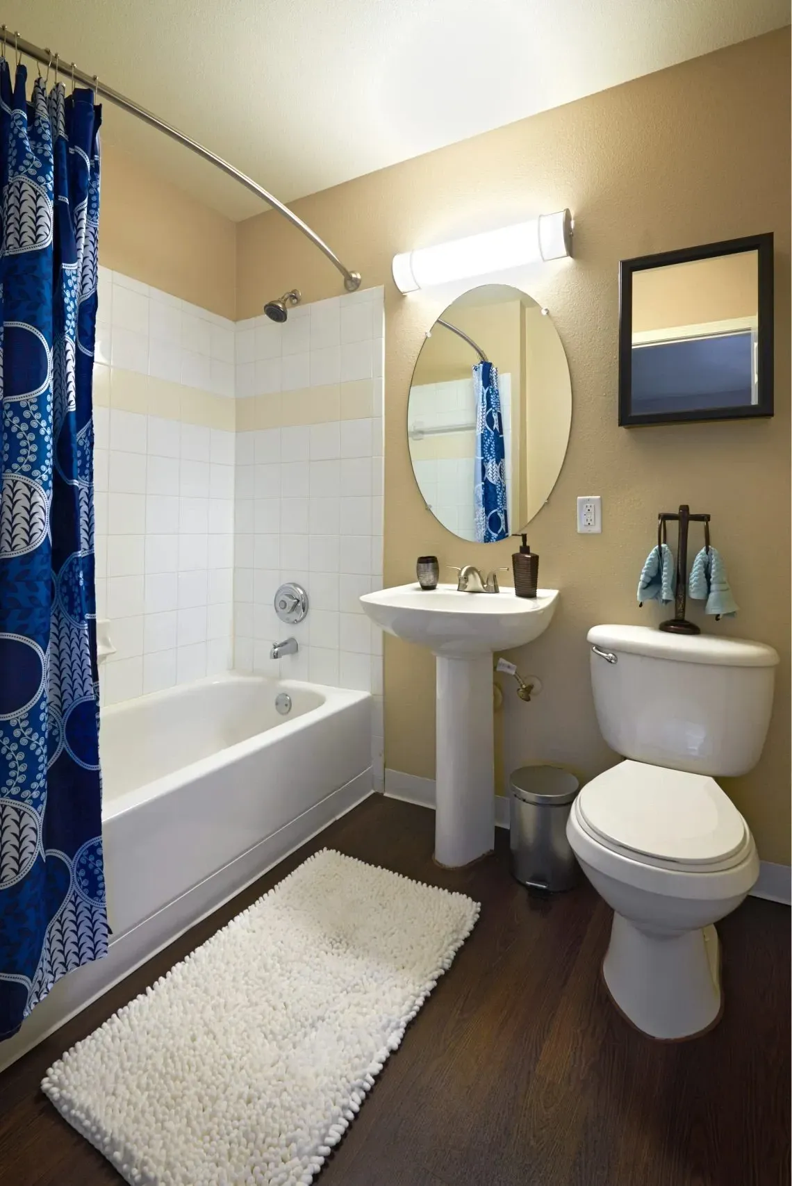 Bathroom with white tub, pedestal sink, and toilet.