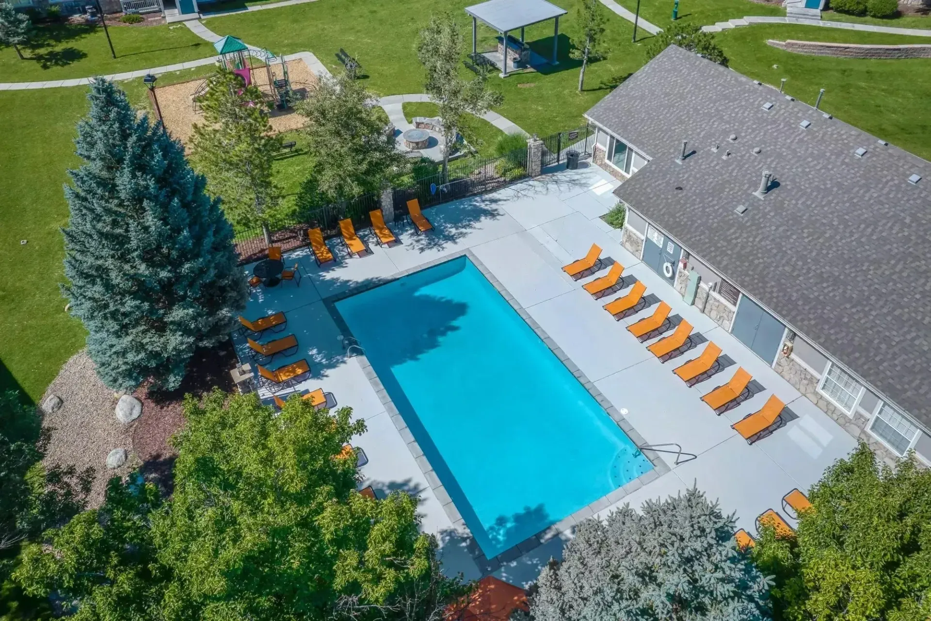 Aerial view of a swimming pool with lounge chairs and a playground.