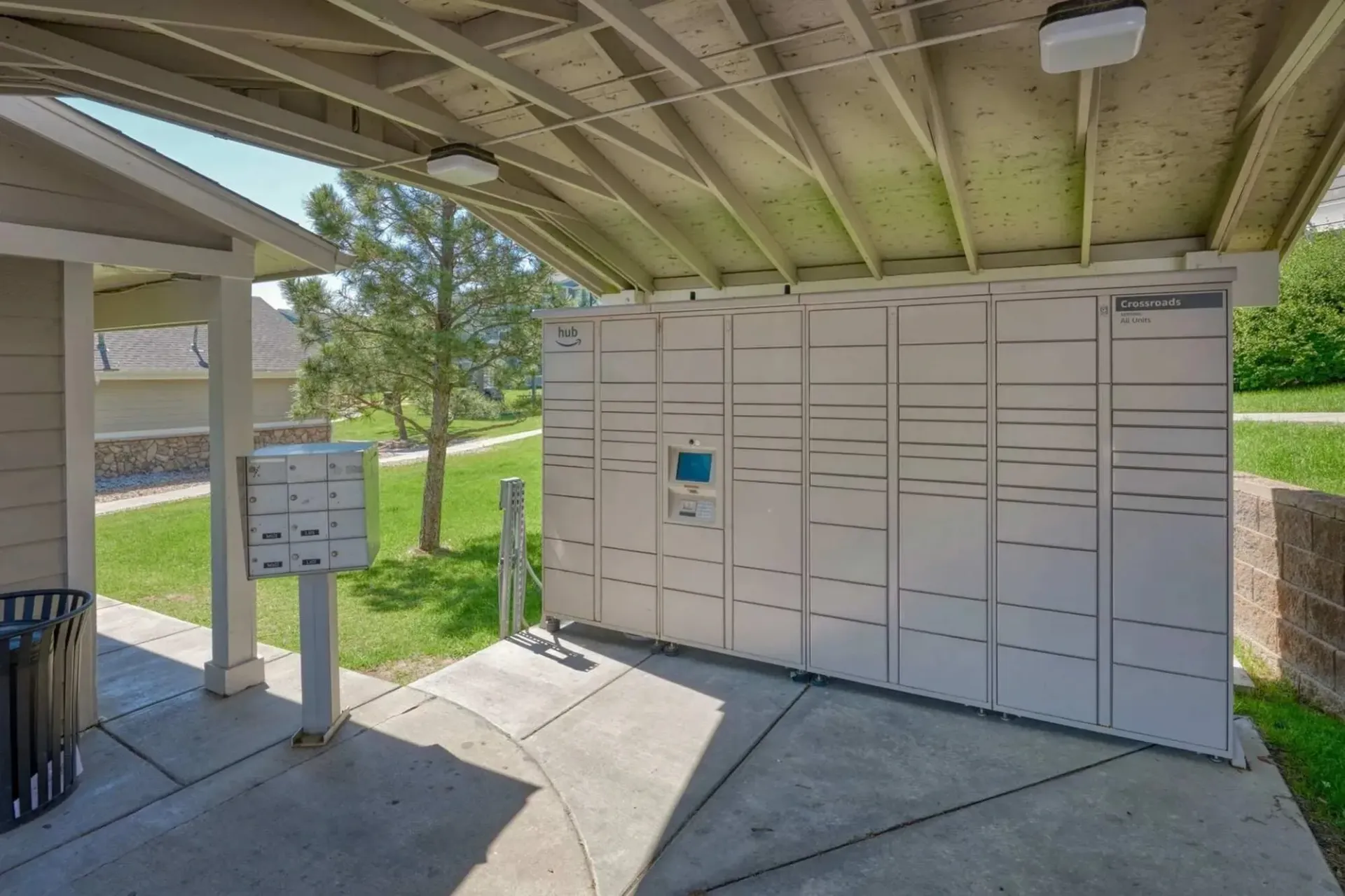 Package lockers and mailboxes under a covered walkway.