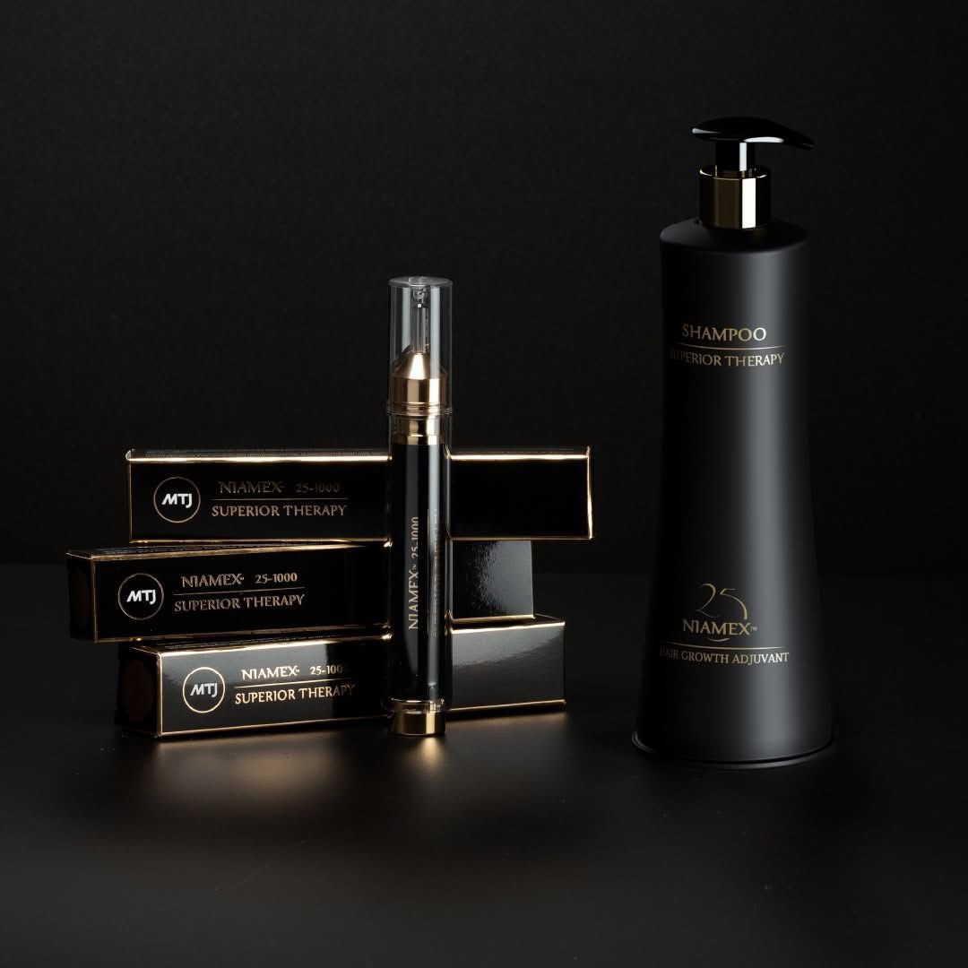 Un set di lusso di prodotti per la cura della pelle nei toni del nero e dell'oro, che comprende un flacone alto con dosatore a pompa, un applicatore a penna e articoli confezionati in un elegante cofanetto.