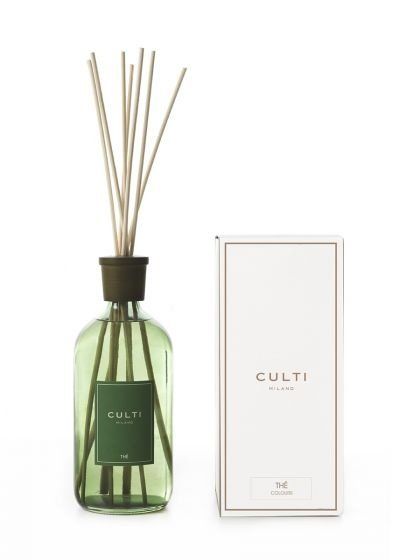 Una bottiglia diffusore in vetro verde con bastoncini di bambù accanto alla sua scatola rettangolare bianca coordinata, entrambe con l'etichetta CULTI.