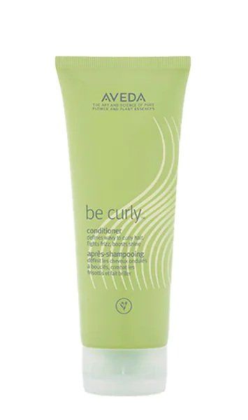 Un tubetto verde chiaro di balsamo Aveda per capelli ricci su sfondo bianco.