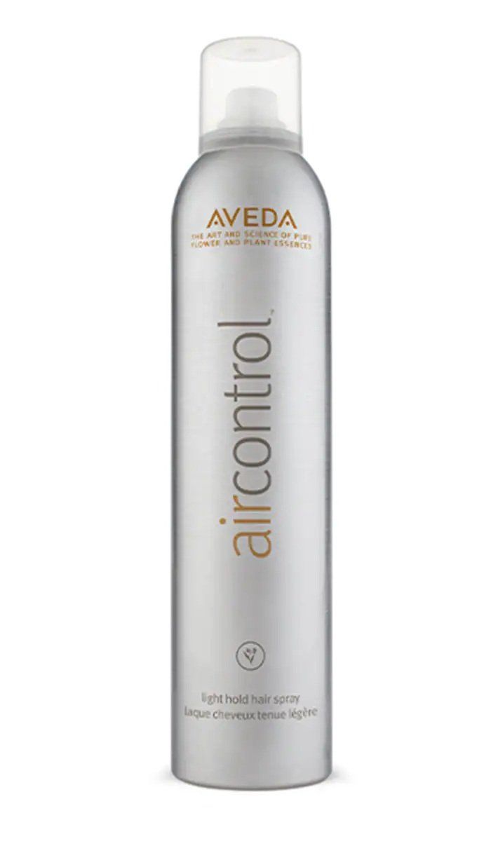 Una bottiglia cilindrica argentata di lacca per capelli Aveda Air Control a tenuta leggera, con tappo trasparente, su sfondo bianco.
