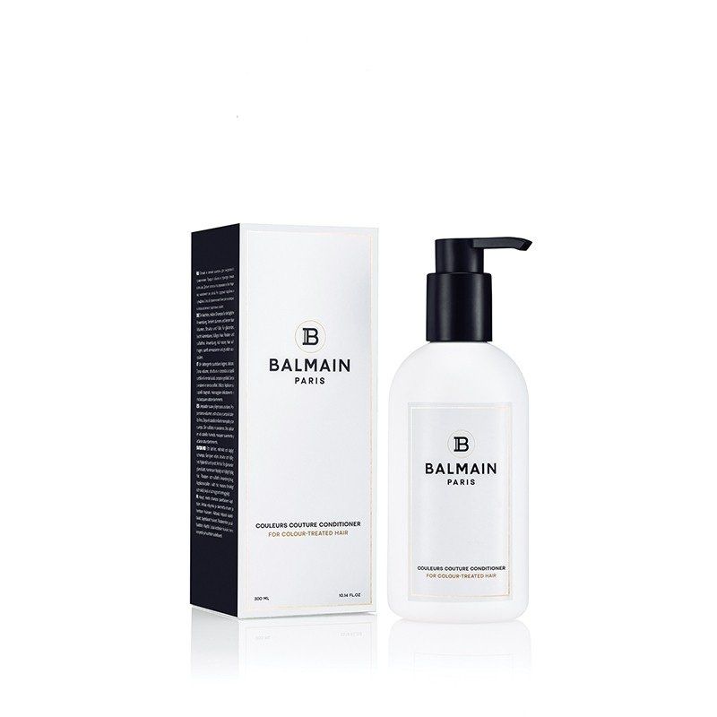 Una bottiglia di shampoo idratante Balmain Paris e la sua scatola rettangolare bianca su sfondo bianco.