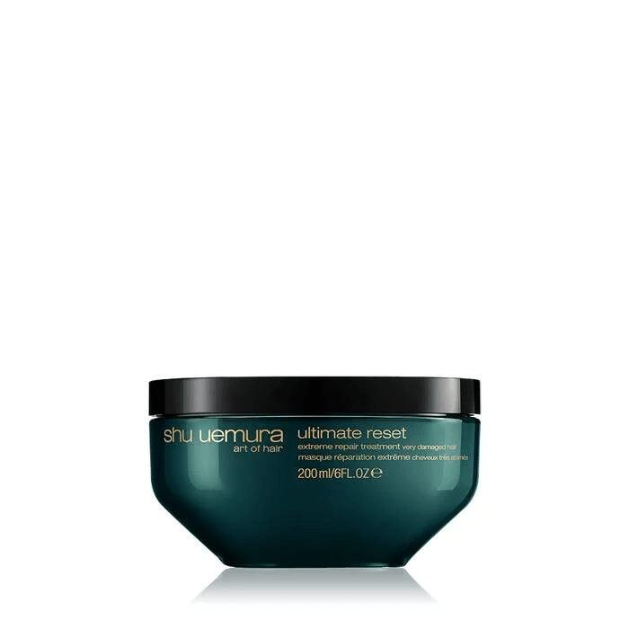 Un vasetto color verde acqua contenente la maschera per capelli Shu Uemura Art of Hair Ultimate Reset con coperchio nero su sfondo bianco.