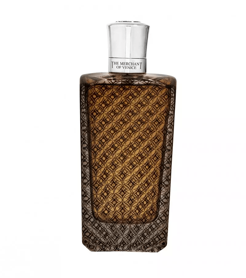 Flacone di profumo in vetro con una decorazione a rombi testurizzata color oro-marrone e tappo argentato su sfondo bianco.