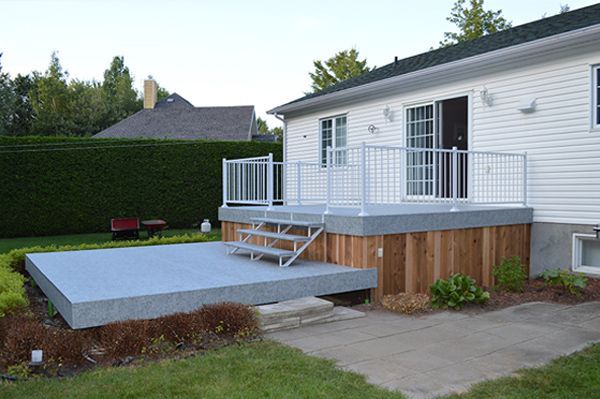 Une maison blanche avec une grande terrasse recouverte de membrane de PVC devant elle