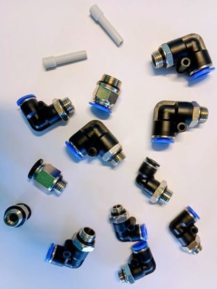 Una colección de varios codos y accesorios rectos neumáticos negros de conexión a presión con dos pequeños tubos de plástico gris.