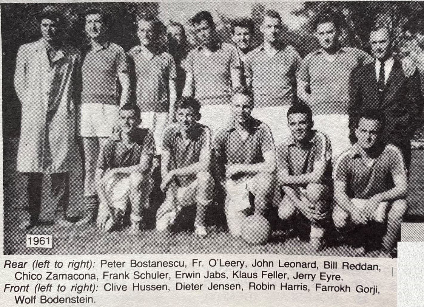 Black-and-white group photo of 1961 football team players and coaches posing outdoors