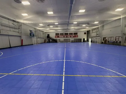 Indoor training facility interior with players training on turf