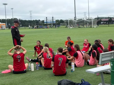 Coaching staff member leading a training session on the field