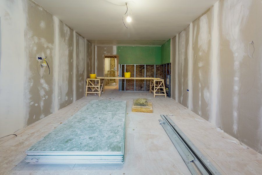 blue wallboard stacked on floor after ceiling installation