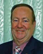 A man in a suit and tie is smiling for the camera.