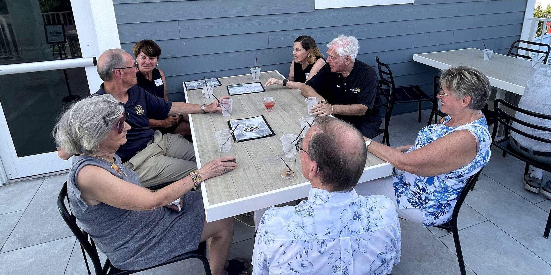 A group of people are sitting around a table talking.