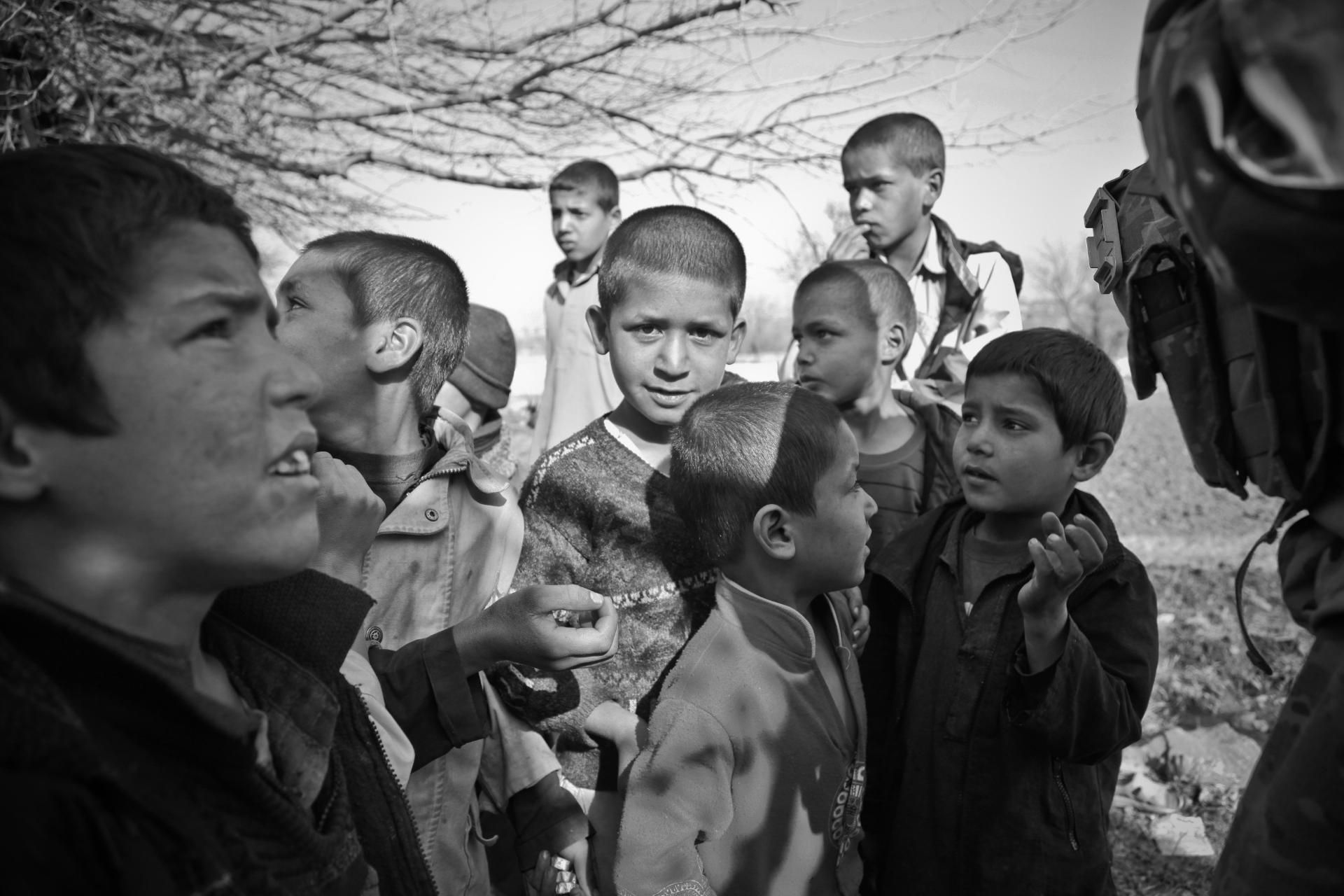 A black and white photo of a group of children standing next to each other.