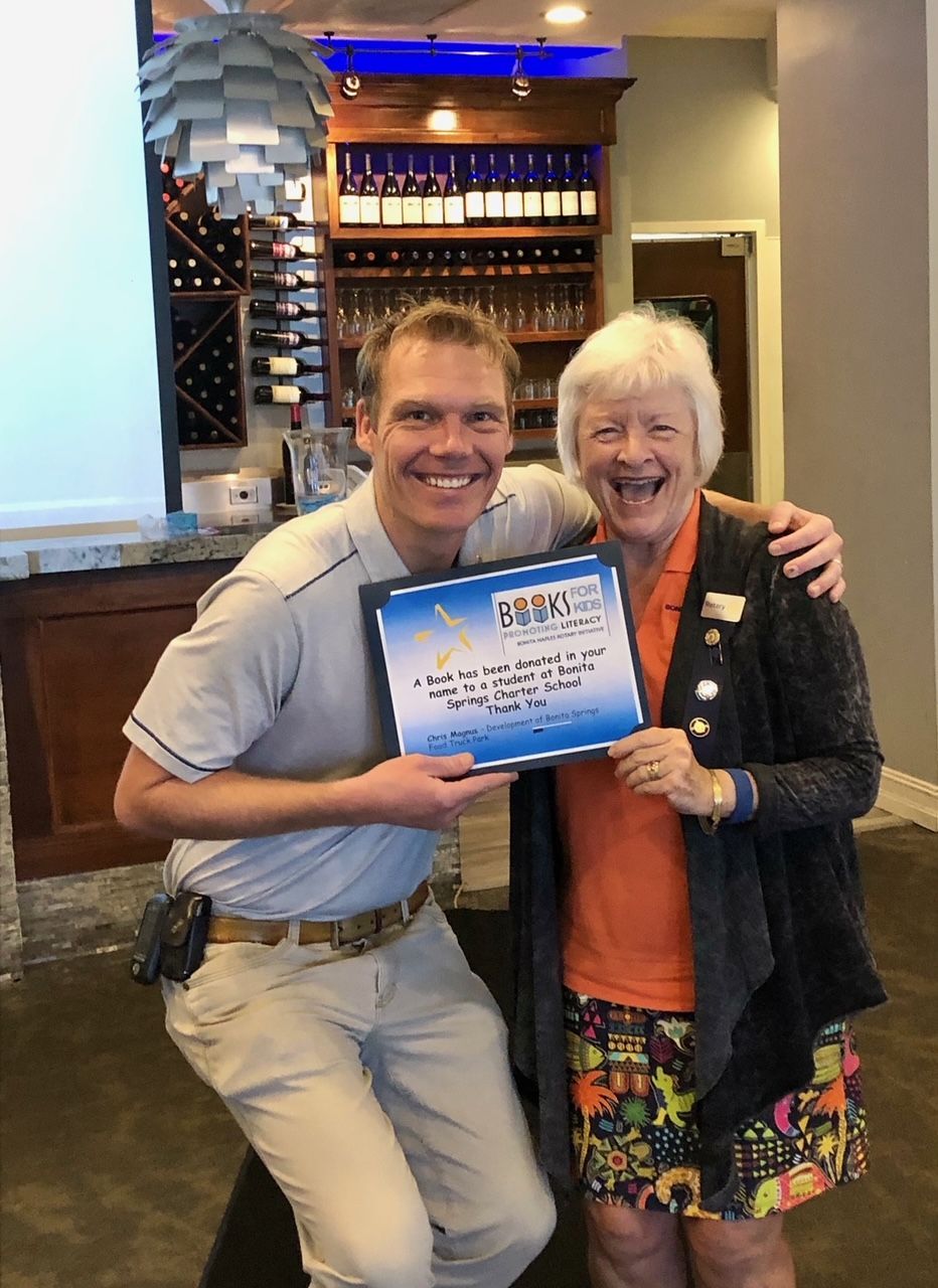 A man and a woman are posing for a picture while the man is holding a certificate.