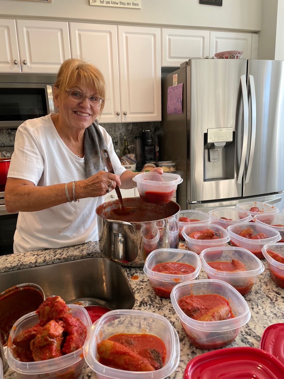 A woman is making tomato sauce in a kitchen.